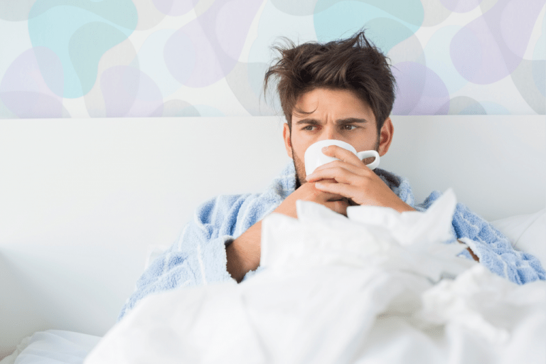 nemocný muž pijící kávu v posteli