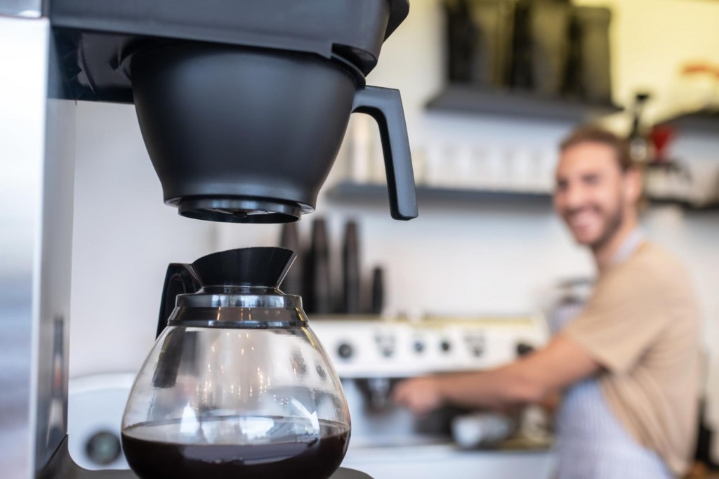 automatický kávovar na překapávanou kávu alias batch brew v kavárně s baristou