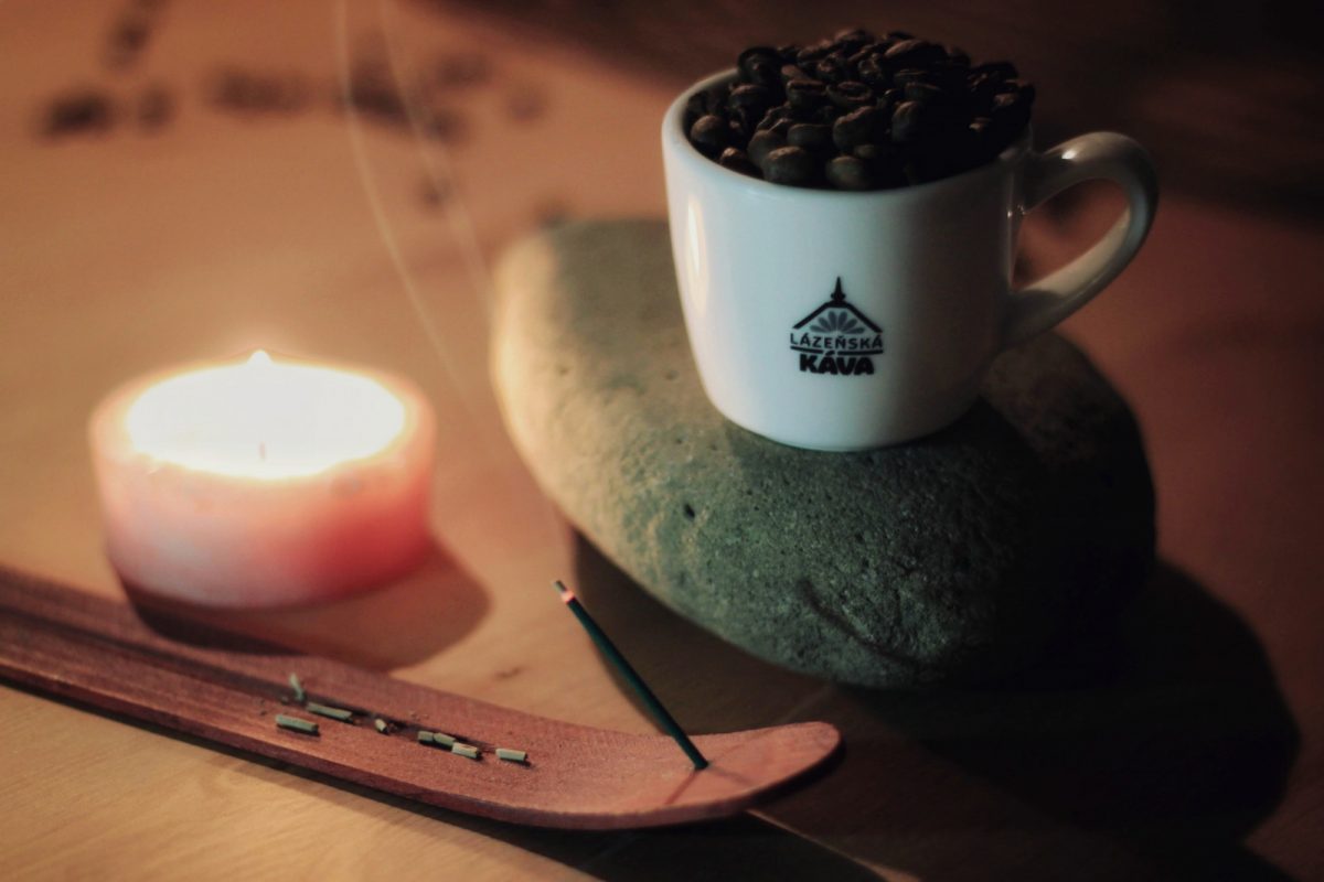 šálek Lázeňská káva s praženou zrnkovou kávou, ájuverdskou svíčkou a santalovým dřevem